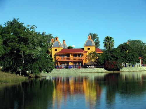 a large yellow house sitting on top of a lake at Canadian Resort Vallarta in Bucerías