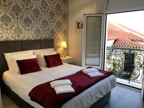 a bedroom with a bed with two towels on it at Casa Varanda do Castelo in Ourém