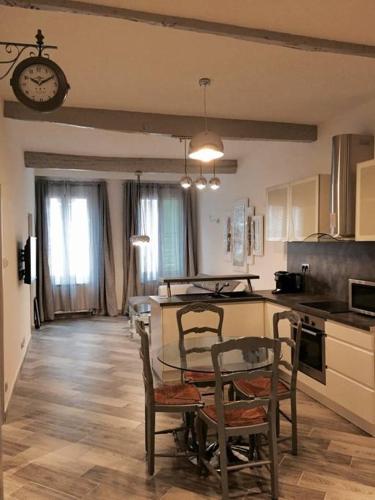 une cuisine avec une table, des chaises et une horloge dans l'établissement Beautiful apartment Rue De La Croix Vieux Nice, à Nice