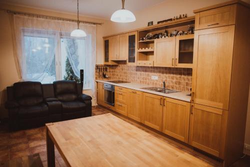 a kitchen with wooden cabinets and a table and a chair at Vilhelma Purvīša 27k.1 in Jūrmala