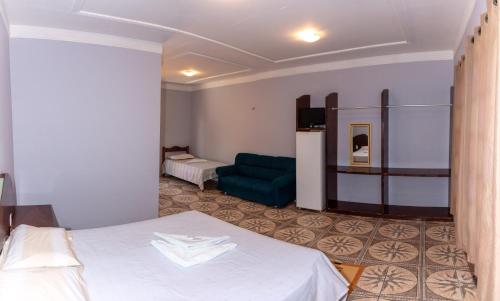 a hotel room with a bed and a couch at Pousada Fortaleza in Canoa Quebrada