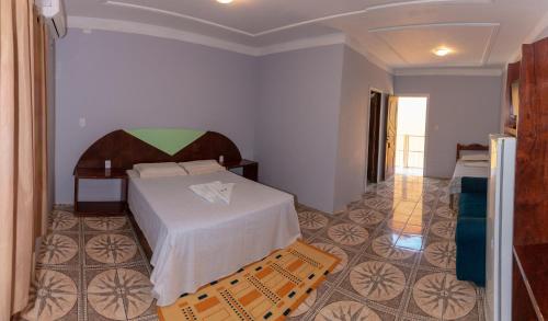 a hotel room with a bed and a chair at Pousada Fortaleza in Canoa Quebrada