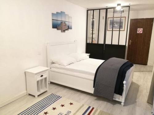 - une chambre avec un lit blanc et une porte noire dans l'établissement Ty Avel, à Quiberon