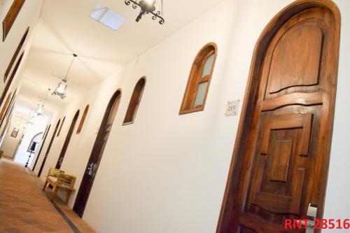 a hallway with a wooden door and a row of windows at Hotel Union in Girardot