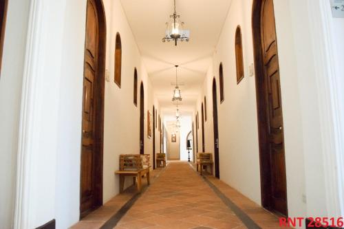 a corridor in a building with white walls and wooden doors at Hotel Union in Girardot