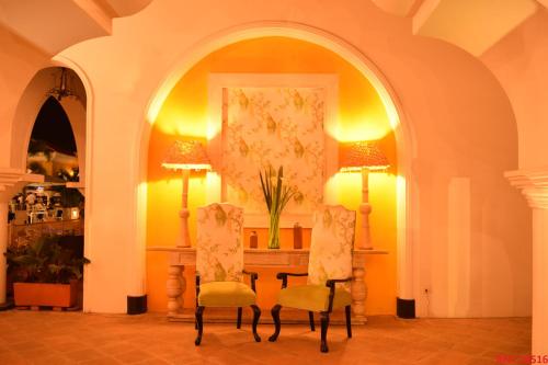 a room with two chairs and a table with two lamps at Hotel Union in Girardot