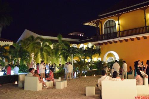 a group of people standing outside of a building at night at Hotel Union in Girardot
