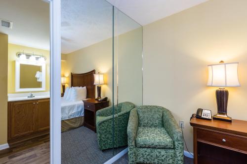 a hotel room with a chair and a bedroom at Jade Tree Cove in Myrtle Beach
