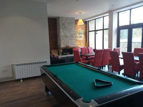 a room with a pool table and red chairs at Chalet Mechka in Borovets