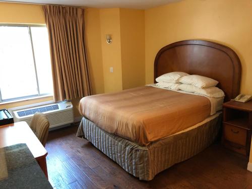 アディスンにあるAmericas Best Value Inn Addisonのベッドと窓のあるホテルの部屋