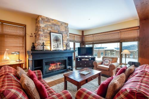 sala de estar con sofá y chimenea en L'Altitude by Rendez-Vous Mont-Tremblant en Mont-Tremblant