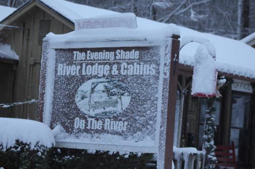 a sign covered in snow in front of a building at The Evening Shade River Lodge and Cabins in Chimney Rock