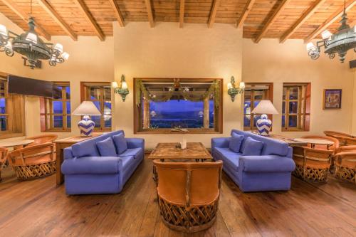 a living room with blue couches and a table at Tapalpa Country Club Hotel in Tapalpa