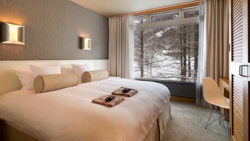 Habitación de hotel con cama grande y ventana en The Green Leaf, Niseko Village, en Niseko