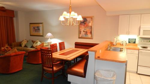 een keuken en een woonkamer met een tafel en een bank bij 1 BR Deluxe Jacuzzi Condo Southern Exposure Oceanview Wyndham Ocean Walk - Daytona Funland 2429 in Daytona Beach