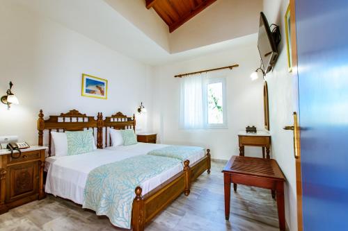 a bedroom with a bed and a table and a window at Anais Collection Hotels & Suites in Kato Daratso