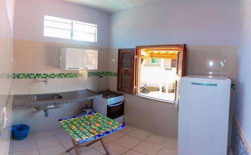 a small kitchen with a sink and a stool in it at Pousada Fortaleza in Canoa Quebrada