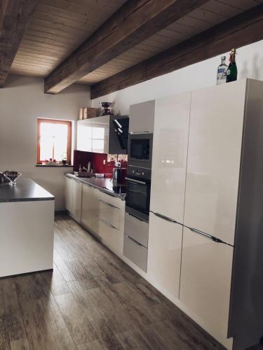 a kitchen with white appliances and a wooden floor at Chata Diana in Vítkovice