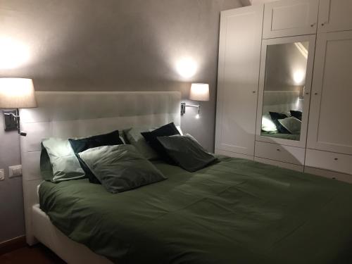 ein Schlafzimmer mit einem großen Bett mit grüner Bettwäsche und Kissen in der Unterkunft la petite maison in Aosta