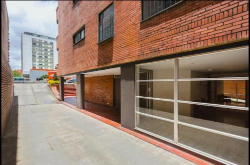 a brick building with large windows on a street at Hospedaje Sary House in Bogotá