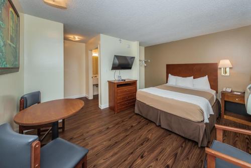 a hotel room with a bed and a table at Tampa Bay Extended Stay Hotel in Largo