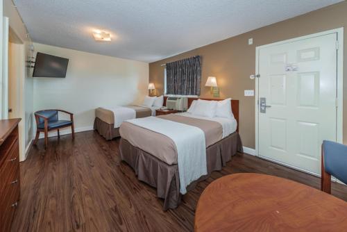 a hotel room with two beds and a television at Tampa Bay Extended Stay Hotel in Largo