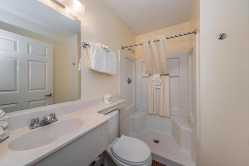 a bathroom with a sink and a toilet and a mirror at Tampa Bay Extended Stay Hotel in Largo