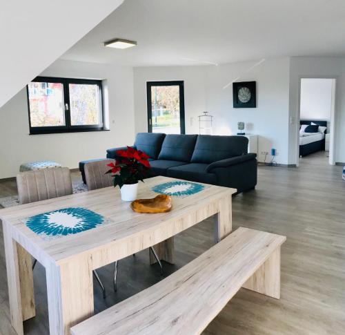 a living room with a blue couch and a table at LUX Ferienwohnungen in Hepbach