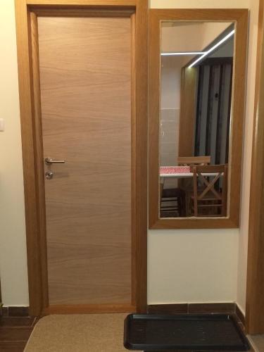 a wooden door in a room with a mirror at Suncani apartman 26 in Brzeće