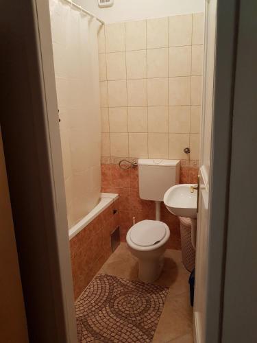 a bathroom with a toilet and a tub and a sink at SARA Apartment in Banja Luka