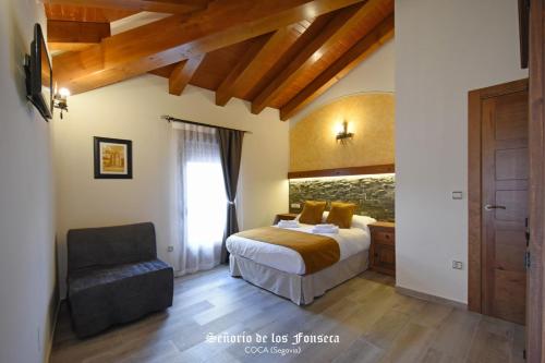 a bedroom with a bed and a chair at Señorío de los Fonseca in Coca