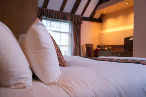 a woman laying on a bed in a hotel room at The Catherine Wheel Wetherspoon Hotel in Henley on Thames