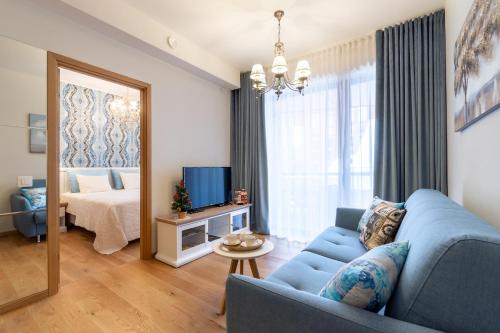 a living room with a blue couch and a bed at Rotermann Square view Apartment in Tallinn