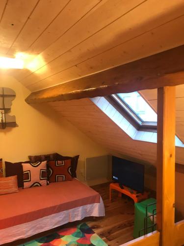 Schlafzimmer im Dachgeschoss mit einem Bett und einem Dachfenster in der Unterkunft Cosy T2 mezzanine pour 4 personnes in Cauterets