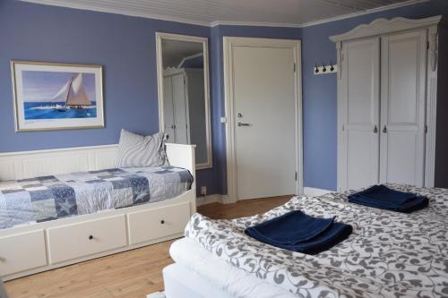 deux lits dans une chambre aux murs bleus dans l'établissement Åsa Gästis, à Åsa