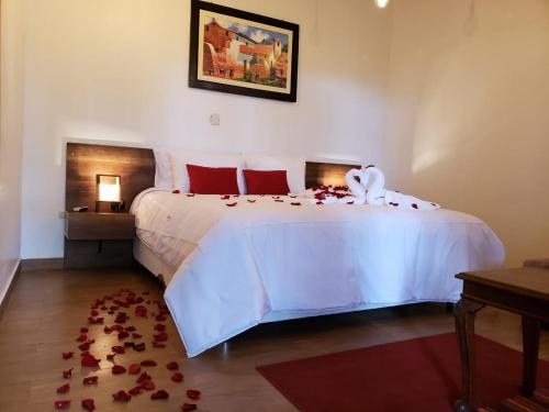 a bedroom with a large white bed with red pillows at La Casona Monsante in Chachapoyas