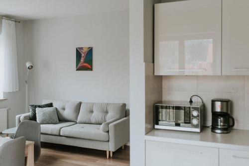 a living room with a couch and a kitchen at Apartament 3 - Bliżej Zdroju in Polanica-Zdrój