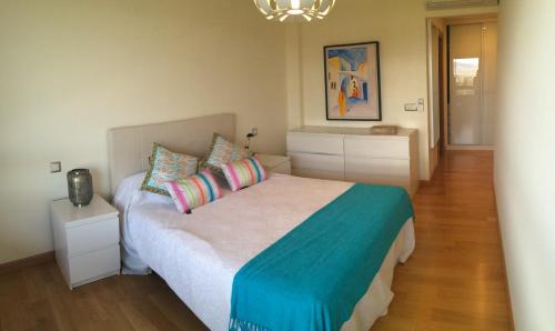 a bedroom with a large bed with colorful pillows at Apartamento Mercedes in Logroño