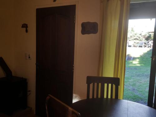 a door to a dining room with a table and a window at Pa-kuas del Uritorco in Capilla del Monte
