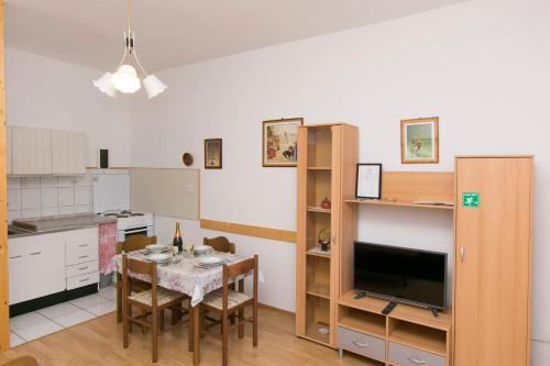 a kitchen with a dining room table and a television at Apartments Amalija in Vodice