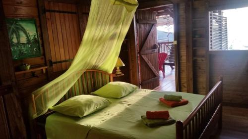 a bedroom with a bed with a mosquito net at villa marguerita in Deshaies
