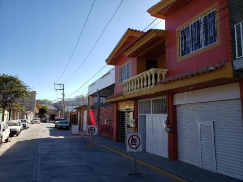 a street with a red building and a no parking sign at Hotel Anturio in Huajuapan de León