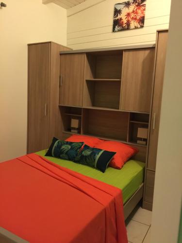 a bedroom with a bed with a red and green blanket at Ô Fil de l'Eau in Pointe-Noire