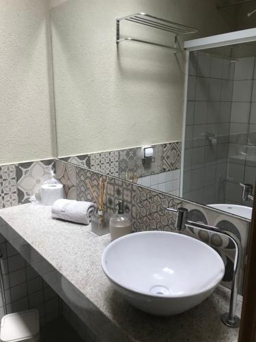 uma casa de banho com um lavatório branco e um espelho. em Casa de São Jorge em Pirenópolis