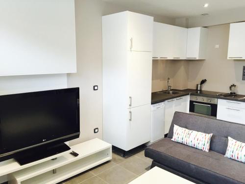 un salon avec un canapé et une télévision à écran plat dans l'établissement Flat on 2 floors near stade de france, à Aubervilliers