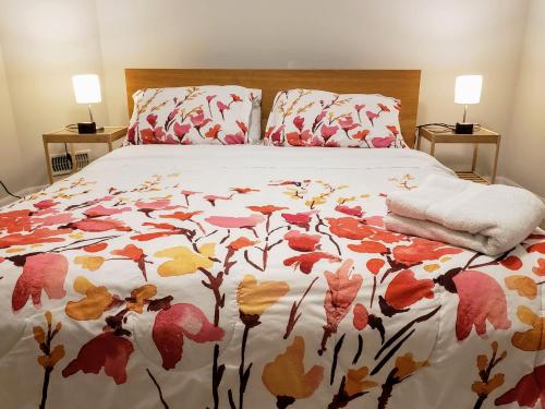a bed with a floral bedspread on it with two lamps at The Suite Vista in Waterloo