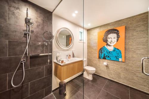 a bathroom with a painting of a man at Lake View Greenstone Luxe Apartment in Queenstown