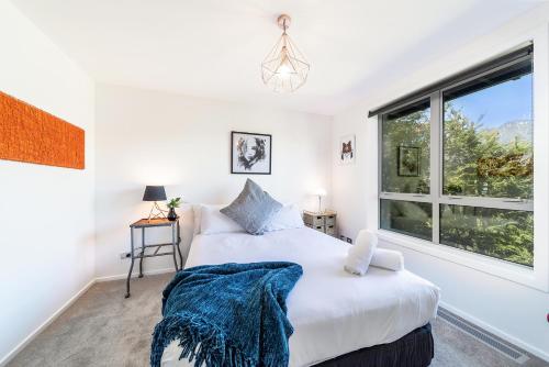 a bedroom with a bed and a window at Lake View Greenstone Luxe Apartment in Queenstown