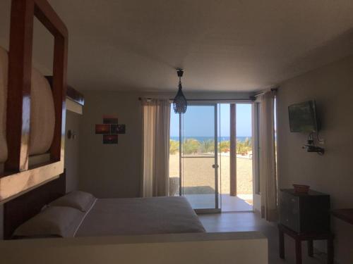 a bedroom with a bed and a view of the ocean at El Samay Hotel Boutique in Canoas De Punta Sal