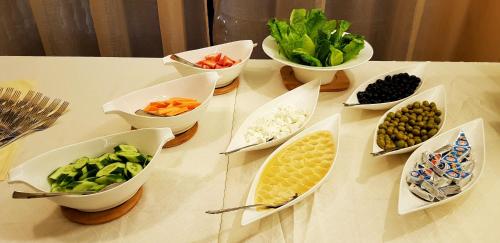 a table topped with bowls of vegetables and other foods at Muscat Plaza Hotel in Muscat